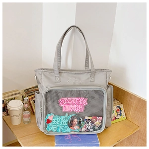 Detail of grey waterproof nylon ita bag featuring a large transparent mesh window and badges