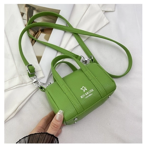 Detailed macro of grass green mini crossbody pillow bag with pebble leather texture