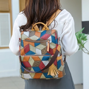 Detailed outdoor shot of a colorful geometric pattern backpack with fringe tassels