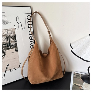 Close-up of vintage brown matte suede tote bag with adjustable shoulder strap detail