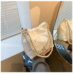 Gros plan du sac seau matelassé blanc avec bandoulière perle et breloques étoiles