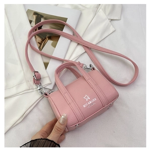 Detail of pink lychee leather mini pillow bag with silver logo and metal bottom studs