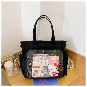 Detail view of a black ita bag with a large clear window for displaying anime accessories