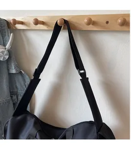 Dettaglio della tracolla regolabile nera su una borsa da viaggio in nylon capiente