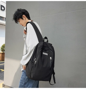 Macro detail of black nylon backpack featuring multi-layer zippers and MACHUGE logo