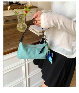 Close-up of light blue woven texture canvas bag with silver metal carbine and black strap