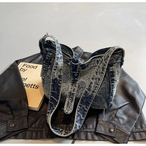 Detail of blue denim tote bag showing distressed wash texture and adjustable grommet strap