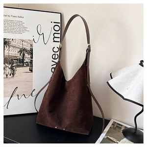 Detail view of dark brown suede hobo bag with adjustable strap and metal bottom studs