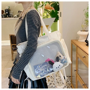 Detailed close-up of a white fashion Itabag with a large transparent display window