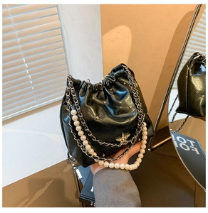 Détail du sac seau noir avec cordon, strass en étoile et bandoulière en perles chic