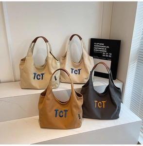 Close-up of stylish canvas tote bags in four colors with TCT embroidery and leather handles