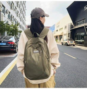 Outdoor street view of the army green nylon backpack with multi-zipper pockets for commute