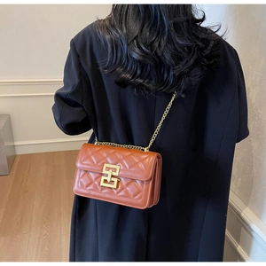 Sac bandoulière matelassé marron caramel avec fermoir doré et chaîne sur le mannequin