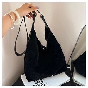 Close-up of vintage black matte suede tote bag with gold buckle and adjustable strap