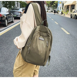 Detail view of olive green functional backpack featuring wide straps and nylon fabric