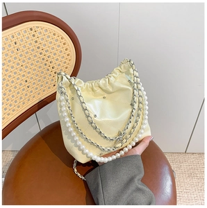 Détail du sac seau matelassé avec bandoulière en perles et accents de cristaux brillants