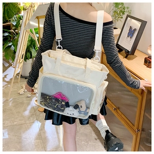 Detail view of large transparent window on off-white nylon ita bag for pin display