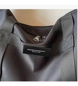 Dettaglio della borsa in tessuto oxford nero con cerniere robuste e manici intrecciati