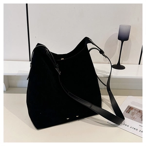 Detail of the black large-capacity suede tote bag with elegant gold hardware and shoulder strap