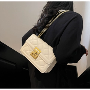 Gros plan sur un sac bandoulière matelassé blanc avec fermoir doré et chaîne en métal