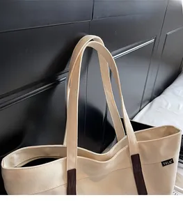 Close-up of beige canvas tote bag showing heavy canvas fabric and brown strap details