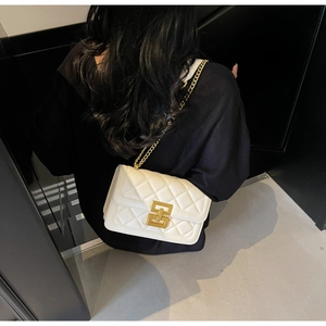Détail du sac bandoulière blanc matelassé avec chaîne dorée et fermoir géométrique