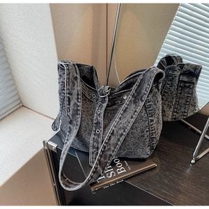Close-up of vintage denim tote bag showing washed fabric texture and metallic eyelets
