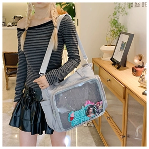 Detail of grey itabag with large transparent window showing anime collectibles
