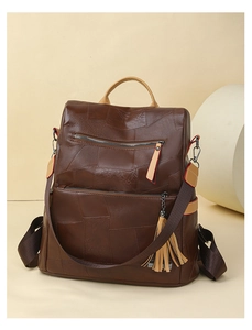 Detailed macro view of vintage brown patchwork leather backpack with metal zipper pockets