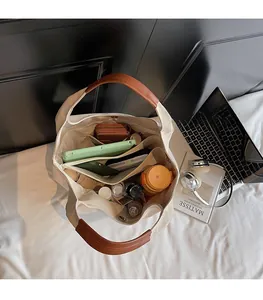 Interior view of beige canvas tote bag showing spacious compartments and brown handles