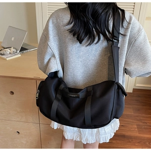 Borsa a tracolla nera in tessuto Oxford indossata da un modello in un ambiente sobrio
