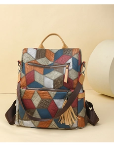 Detail of color-block textured leather backpack with diamond patterns and fringe pendant