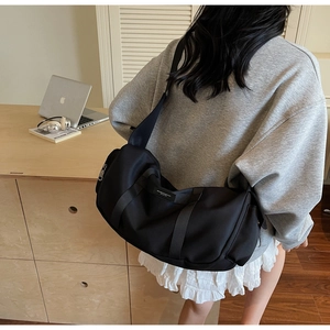 Vista dettagliata di una borsa a tracolla nera in tessuto oxford sulla spalla in interni