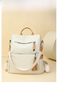 Detail of lychee pattern faux leather backpack with patchwork and tassel charm