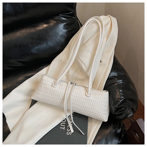 Detail of white woven leather texture on a minimalist rectangular baguette underarm bag