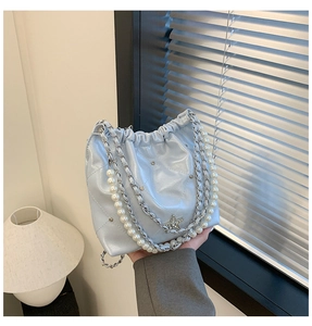 Détails du sac seau bleu clair avec chaîne argentée, bandoulière perles et étoile