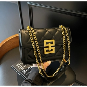 Détail du sac à chaîne en cuir matelassé noir avec fermoir géométrique doré et sangle