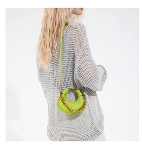 Close-up of bright green crescent handbag with gold chain and litchi texture leather