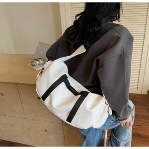 Dettaglio di una grande borsa a tracolla bianca in tessuto Oxford con cinghie nere e cerniera