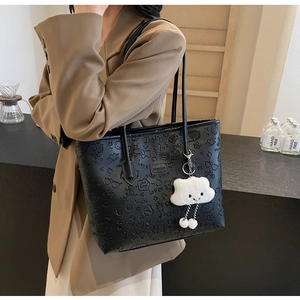 Borsa tote nera goffrata con motivi graffiti e ciondolo a nuvola indossata da una modella