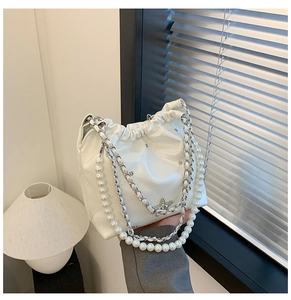 Détail du sac seau matelassé blanc avec bandoulière perle, chaîne et pendentif étoile