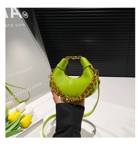 Close-up of bright green crescent bag with litchi grain and chunky gold chain