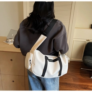 Dettaglio della borsa sportiva in nylon bianco con tracolla nera e astuccio laterale