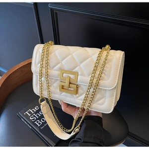 Détail du sac bandoulière beige matelassé avec fermoir géométrique doré et chaîne