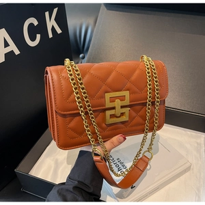 Détail du sac matelassé caramel avec boucle dorée et bandoulière en chaîne