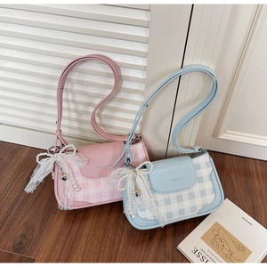 Detail of pink and blue checkered crossbody bags with lace bows and pearl charms