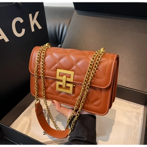 Détails d'un sac en cuir matelassé caramel avec chaîne dorée élégante et fermoir métallique