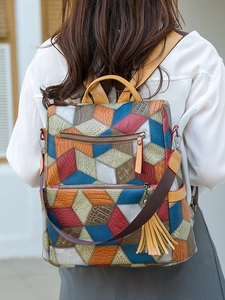 Outdoor shot of a geometric 3D puzzle pattern backpack with dual zippers and yellow tassel