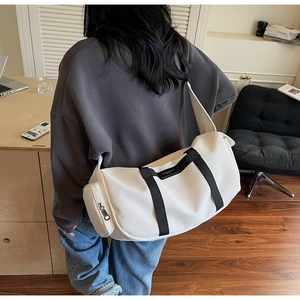 Dettaglio della borsa a tracolla beige in tessuto Oxford con ampia tracolla nera