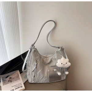 Silver metallic shoulder bag with cloud pendant and casual textured finish in life scene